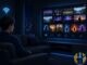 Anime-style man on a couch watching a merged live TV and movie player interface with blue tech accents