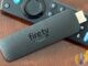 Amazon Fire TV Stick and remote on wood table; Fire TV Beta Access Program September 2026