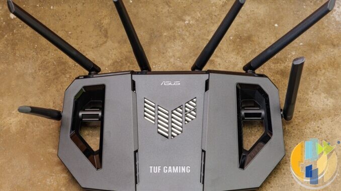Real ASUS TUF gaming Wi-Fi router on a wooden desk — living-room router hardware that often decides whether a Google TV stick buffers or plays cleanly.
