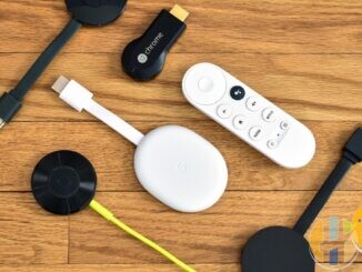 Real collection of Chromecast streaming sticks and a Google TV remote laid out on a wooden desk — multi-generation stick hardware for side-by-side comparison context; no Strong or Xiaomi forged marks.
