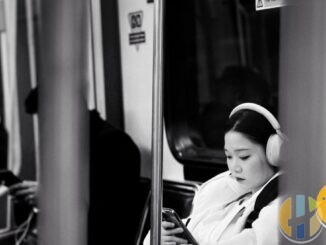 Documentary photo of a woman on public transit looking at her phone — travel and public-network mobile context without VPN brand forge.
