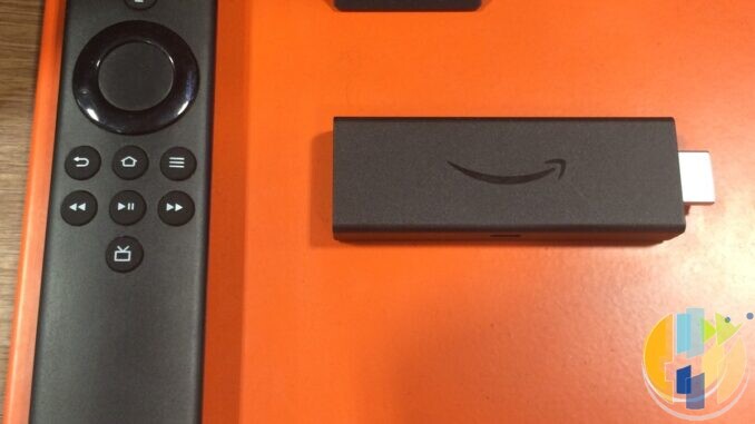 Real Amazon Fire TV Stick and Alexa Voice Remote on an orange display surface — everyday second-room streaming stick alternative; no TalkTalk or YouView forged marks.