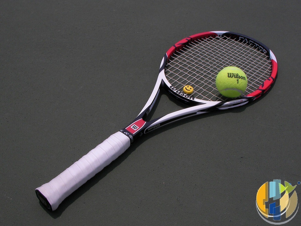 Tennis racket and yellow ball on a hard court