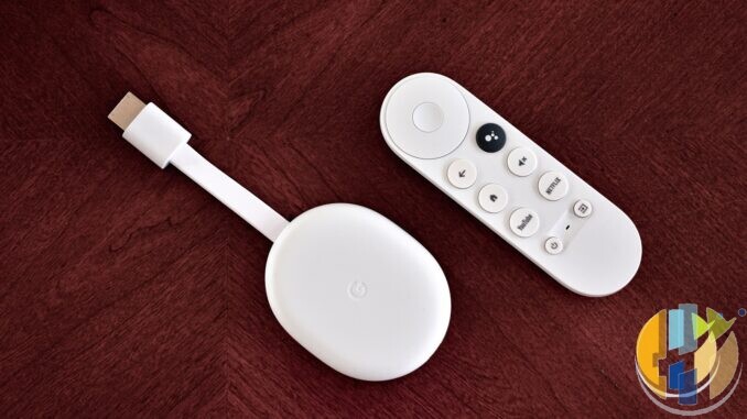 White Chromecast with Google TV dongle and its remote lying on a dark red wooden table