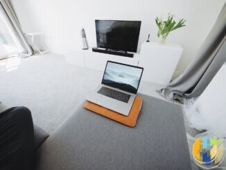 Laptop on a living-room ottoman with a blank television in the background, illustrating home streaming setup before a platform shutdown