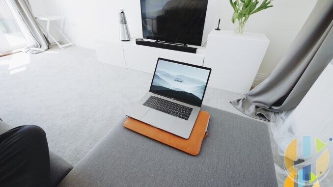Laptop on a living-room ottoman with a blank television in the background, illustrating home streaming setup before a platform shutdown